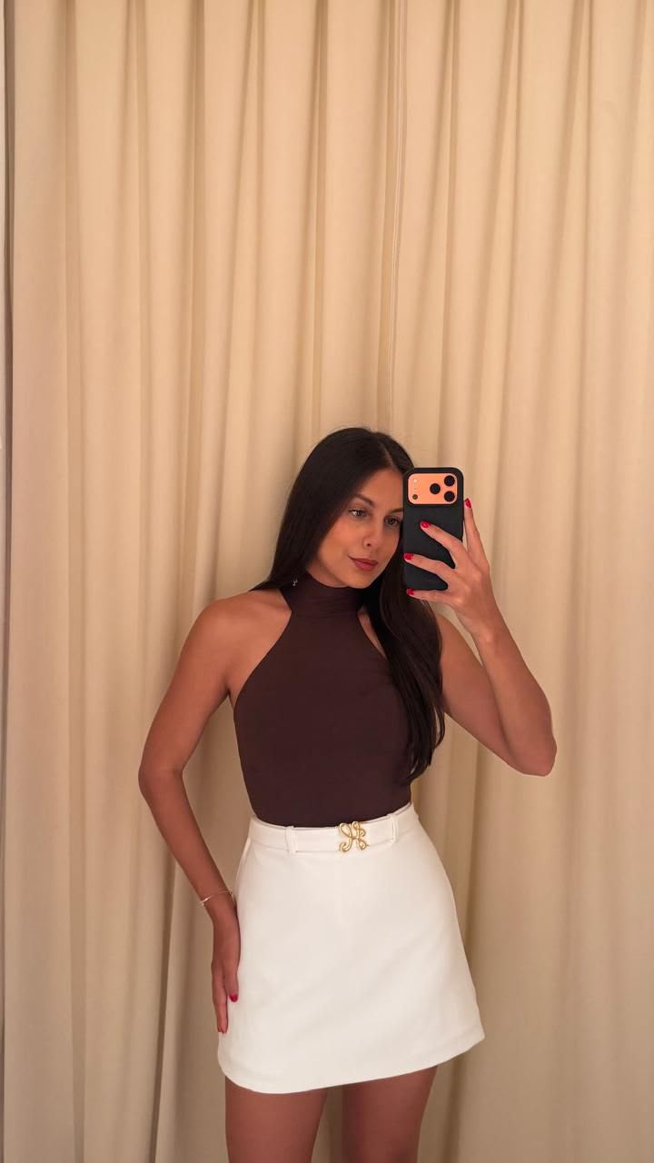 Mulher vestindo blusa marrom e saia